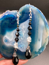Load image into Gallery viewer, These shimmering black and silver glass beaded earrings feature a large black teardrop glass bead for added movement. This sophisticated and versatile accessory can be worn for an elegant evening look, brunch ensemble, wedding necklace, or minimalist style. Measurements: 2 1/2” in length