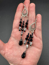 Load image into Gallery viewer, This stylish three-strand black and silver glass beaded earring design presents a beautiful dancing effect, boasting a large black teardrop glass bead. A versatile accessory, it suits a variety of ensembles from cocktail chic to wedding fineries, and its minimalist aesthetic lends a modern charm.  Measurements: 3 3/4” in length