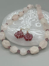 Load image into Gallery viewer, Add a touch of bohemian style to your look with these unique light purple pink flower glass earrings. Featuring detailed pressed glass beads and an iridescent shimmer finish, these earrings are perfect for a hippie vibe, shabby chic, or boho chic look. Nature-inspired and chic, these are the perfect earrings for any occasion. Measurements: 1 1/4" length