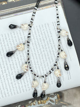 Load image into Gallery viewer, Black And White Vampire Goth Skulls Choker Style Necklace, Skully Witchy Vibe, Goth Dark Souls Jewelry, Day Of The Dead, Dia De Los Muertos, Howlite Skull Beads Black And Silver Glass BeadsThis statement necklace radiates a dark, shimmering aesthetic with two strands of glass beads connected through double-hole silver and black beads to create a collar shape. These dangling skulls beads are acompanied by black teardrop glass beads enable the piece to flow elegantly and express a bold, fierce look.