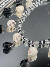 Load image into Gallery viewer, Black And White Vampire Goth Skulls Choker Style Necklace, Skully Witchy Vibe, Goth Dark Souls Jewelry, Day Of The Dead, Dia De Los Muertos, Howlite Skull Beads Black And Silver Glass BeadsThis statement necklace radiates a dark, shimmering aesthetic with two strands of glass beads connected through double-hole silver and black beads to create a collar shape. These dangling skulls beads are acompanied by black teardrop glass beads enable the piece to flow elegantly and express a bold, fierce look.