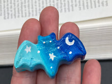 Load image into Gallery viewer, Cute and spooky magnet design to adorn your refrigerator, lockers, workstation, toolbox, or dishwasher. This hand-sculpted clay bat statuette boasts stunning ombre coloration, transitioning from dark blue to light blue to recreate the breathtaking look of a starry night sky. H 1” x W 2” x D 1/2”