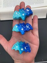 Load image into Gallery viewer, Ideal magnet design to adorn your refrigerator, lockers, workstation, toolbox, or dishwasher. This hand-sculpted clay bat statuette boasts stunning ombre coloration, transitioning from dark blue to light blue to recreate the breathtaking look of a starry night sky. H 1” x W 2” x D 1/2”