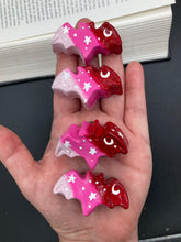 Load image into Gallery viewer, Cute and spooky magnet design to adorn your refrigerator, lockers, workstation, toolbox, or dishwasher. This hand-sculpted clay bat statuette boasts stunning ombre coloration, transitioning from black to dark red to light pink to recreate the breathtaking look of a starry night sky. H 1” x W 2” x D 1/2”