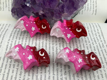 Load image into Gallery viewer, Cute and spooky magnet design to adorn your refrigerator, lockers, workstation, toolbox, or dishwasher. This hand-sculpted clay bat statuette boasts stunning ombre coloration, transitioning from black to dark red to light pink to recreate the breathtaking look of a starry night sky. H 1” x W 2” x D 1/2”