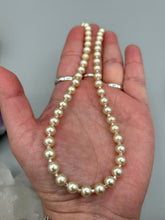 Load image into Gallery viewer, This single strand necklace features gold tone faux pearl beads for a classic, elegant aesthetic. Measurements: Necklace is 18" in length