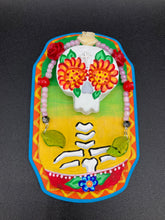 Load image into Gallery viewer, Transform your walls with this handcrafted polymer clay wall art. Showcasing a vibrant Frida Kahlo inspired calavera with hand-beaded floral crown, this Day of the Dead wall decor piece is perfect for adding a traditional Mexican folk art touch to any home.