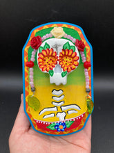 Load image into Gallery viewer, Transform your walls with this handcrafted polymer clay wall art. Showcasing a vibrant Frida Kahlo inspired calavera with hand-beaded floral crown, this Day of the Dead wall decor piece is perfect for adding a traditional Mexican folk art touch to any home.