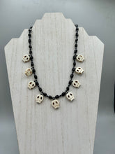Load image into Gallery viewer, This black and white Goth-style necklace displays a series of shimmering dark-toned glass beads that gracefully encircle the neck and feature hanging skull-shaped beads. A powerful, bewitching and audacious piece of jewelry.  Measurements: 19 1/4"
