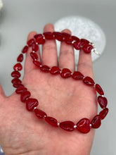 Load image into Gallery viewer, This ruby red heart-shaped glass beaded necklace features a shimmery, translucent finish and a lobster claw clasp. Measurements: Necklace is 18 1/2" in length