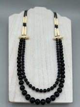 Load image into Gallery viewer, This two-strand necklace features a selection of natural black obsidian stone, hematite, bone, and glass beads. This neutral-hued accessory enhances any ensemble. Measurements: Necklace is 29” in length, can be adjusted up to 30" in length