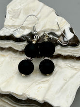 Load image into Gallery viewer, These two-bead flat matte black glass earrings are perfect for any look. With their subtle yet elegant design, they are a great accessory for any closet. 1 1/4” in length