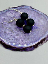 Load image into Gallery viewer, These two-bead flat matte black glass earrings are perfect for any look. With their subtle yet elegant design, they are a great accessory for any closet. 1 1/4” in length