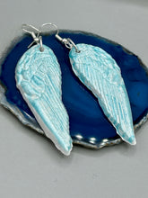 Load image into Gallery viewer, Light baby blue wings earrings made of polymer clay. These earrings are designed to face forward when worn instead of the front wings showing on the side.