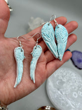 Load image into Gallery viewer, Light baby blue wings earrings made of polymer clay. These earrings are designed to face forward when worn instead of the front wings showing on the side.