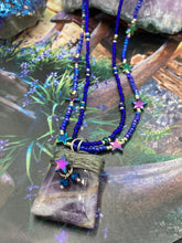 Load image into Gallery viewer, This elegant amethyst trapezoid pendant is artfully wirewrapped with a hematite star bead, making this a unique piece perfect for any occasion. Its two strands of colorful glass beads in a mix of cool blues, purples, and silver create an enchanting, starry night look sure to make a statement. Necklace is 16” in length and can be adjusted to 18"