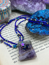 Load image into Gallery viewer, This elegant amethyst trapezoid pendant is artfully wirewrapped with a hematite star bead, making this a unique piece perfect for any occasion. Its two strands of colorful glass beads in a mix of cool blues, purples, and silver create an enchanting, starry night look sure to make a statement. Necklace is 16” in length and can be adjusted to 18"