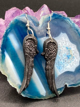 Load image into Gallery viewer, Shimmery black angel wings earrings made of polymer clay. These earrings are designed to face forward when worn instead of the front wings showing on the side.