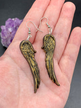 Load image into Gallery viewer, Sparkling gold tone angel wings earrings made of polymer clay. These earrings are designed to face forward when worn instead of the front wings showing on the side.