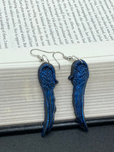 Load image into Gallery viewer, These eye-catching electric blue angel wings earrings are expertly crafted from polymer clay. Featuring an innovative design, they ensure the wings face forward when worn.