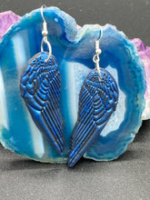 Load image into Gallery viewer, These eye-catching electric blue angel wings earrings are expertly crafted from polymer clay. Featuring an innovative design, they ensure the wings face forward when worn.