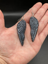 Load image into Gallery viewer, Chrome-colored silver angel wings earrings crafted with polymer clay. Featuring a construction designed to ensure the front wings face forward when worn.