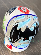 Load image into Gallery viewer, This Ceramic Skull Art With Bat Silhouettes And Flowers is a beautiful mini goth witchy altar skull, with detailed hand painted features. Inspired by the vibrant blooms of the Dawn Redwood, it captures the beauty of the changing of seasons. Perfect for adding a touch of whimsical enchantment to any home. Measurements: H 2 3/4” x W 2” x D 2”