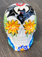 Load image into Gallery viewer, This Ceramic Skull Art With Bat Silhouettes And Flowers is a beautiful mini goth witchy altar skull, with detailed hand painted features. Inspired by the vibrant blooms of the Dawn Redwood, it captures the beauty of the changing of seasons. Perfect for adding a touch of whimsical enchantment to any home. Measurements: H 2 3/4” x W 2” x D 2”