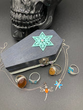 Load image into Gallery viewer, Handmade Vintage Inspired Gothic Victorian Coffin Jewelry Box. Black Wood Coffin Ring Box, Seafoam Blue Star Shape Veneer Floral Embellishment. Dark and whimsical theme keepsake box with dragonfly and shimmer gems. Starry Night Jewelry Box. Interior lined mandala pattern fabric. Holds several rings or jewelry pieces. Dark, Beautiful, Unique Gift for the BOLD. Makes a great keepsake box! Or you could also just let your cat admire it before he knocks it off the table, too.