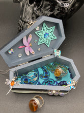 Load image into Gallery viewer, Handmade Vintage Inspired Gothic Victorian Coffin Jewelry Box. Black Wood Coffin Ring Box, Seafoam Blue Star Shape Veneer Floral Embellishment. Dark and whimsical theme keepsake box with dragonfly and shimmer gems. Starry Night Jewelry Box. Interior lined mandala pattern fabric. Holds several rings or jewelry pieces. Dark, Beautiful, Unique Gift for the BOLD. Makes a great keepsake box! Or you could also just let your cat admire it before he knocks it off the table, too.