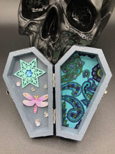 Load image into Gallery viewer, Handmade Vintage Inspired Gothic Victorian Coffin Jewelry Box. Black Wood Coffin Ring Box, Seafoam Blue Star Shape Veneer Floral Embellishment. Dark and whimsical theme keepsake box with dragonfly and shimmer gems. Starry Night Jewelry Box. Interior lined mandala pattern fabric. Holds several rings or jewelry pieces. Dark, Beautiful, Unique Gift for the BOLD. Makes a great keepsake box! Or you could also just let your cat admire it before he knocks it off the table, too.