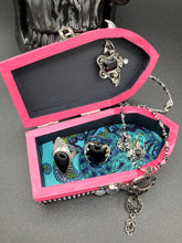Load image into Gallery viewer, This unique handmade Pink Spooky Glam Wood Coffin Ring Box offers a statement piece for your witchy home decor. Its macabre collections boast a black and pink wood coffin with large shimmery bat embellishments and decorative black crystals around the exterior. Open up the box to find a bright turquoise mandala fabric and a tiny black crystal bat decoration for a truly eerie feel.