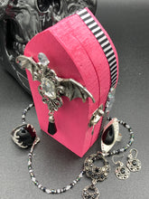 Load image into Gallery viewer, This unique handmade Pink Spooky Glam Wood Coffin Ring Box offers a statement piece for your witchy home decor. Its macabre collections boast a black and pink wood coffin with large shimmery bat embellishments and decorative black crystals around the exterior. Open up the box to find a bright turquoise mandala fabric and a tiny black crystal bat decoration for a truly eerie feel.