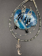 Load image into Gallery viewer, This stylish three-strand black and silver glass beaded earring design presents a beautiful dancing effect, boasting a large black teardrop glass bead. A versatile accessory, it suits a variety of ensembles from cocktail chic to wedding fineries, and its minimalist aesthetic lends a modern charm.  Measurements: 3 3/4” in length