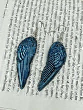 Load image into Gallery viewer, Sparkling light blue angel wings earrings made of polymer clay. These earrings are designed to face forward when worn instead of the front wings showing on the side.