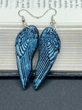 Load image into Gallery viewer, Sparkling light blue angel wings earrings made of polymer clay. These earrings are designed to face forward when worn instead of the front wings showing on the side.