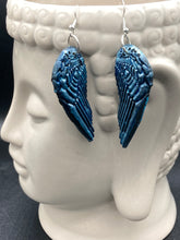 Load image into Gallery viewer, Sparkling light blue angel wings earrings made of polymer clay. These earrings are designed to face forward when worn instead of the front wings showing on the side.