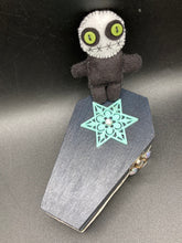 Load image into Gallery viewer, Black and white Voodoo Doll stands at 3" in height. He has an all black body with a white round head. Bulging lime green button eyes and sowed shut mouth to give him a little creepy face of course.
