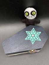 Load image into Gallery viewer, Black and white Voodoo Doll stands at 3" in height. He has an all black body with a white round head. Bulging lime green button eyes and sowed shut mouth to give him a little creepy face of course.