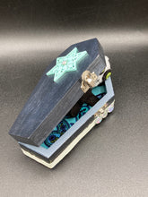 Load image into Gallery viewer, Black and white Voodoo Doll stands at 3" in height. He has an all black body with a white round head. Bulging lime green button eyes and sowed shut mouth to give him a little creepy face of course.