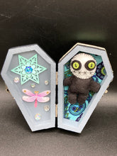 Load image into Gallery viewer, Black and white Voodoo Doll stands at 3" in height. He has an all black body with a white round head. Bulging lime green button eyes and sowed shut mouth to give him a little creepy face of course.