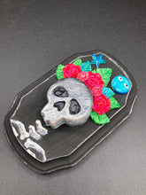 Load image into Gallery viewer, Showcasing a dark theme Frida Kahlo inspired calavera with a dark wood frame, this Day of the Dead wall decor piece is perfect for adding a traditional Mexican folk art touch to any home. Featuring an intricately detailed clay calavera in the style of Frida Kahlo, this Day of the Dead wall art decor is sure to be the centerpiece of any home décor. The calavera is wearing Frida's iconic crown of flowers, ensuring it will bring both a unique and inspiring look to any wall.