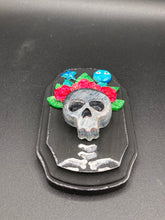 Load image into Gallery viewer, Showcasing a dark theme Frida Kahlo inspired calavera with a dark wood frame, this Day of the Dead wall decor piece is perfect for adding a traditional Mexican folk art touch to any home. Featuring an intricately detailed clay calavera in the style of Frida Kahlo, this Day of the Dead wall art decor is sure to be the centerpiece of any home décor. The calavera is wearing Frida's iconic crown of flowers, ensuring it will bring both a unique and inspiring look to any wall.