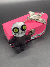 Load image into Gallery viewer, Black and white Voodoo Doll stands at 3" in height. He has an all black body with a white round head. Bulging lime green button eyes and sowed shut mouth to give him a little creepy face of course.