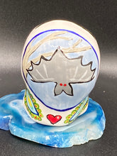 Load image into Gallery viewer, Inspired by nature, this ceramic skull statuette is full of vibrant color and intricate details. The primary color is white with a batty for bats theme and with multi-color floral motifs, along with hearts and leaves and lively colorful accents around the entire skull. Measurements: H 2 3/4” x W 2” x D 2”
