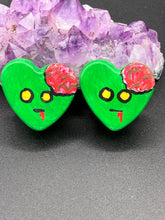 Load image into Gallery viewer, Perfect cute and spooky Halloween item to add to your fridge, locker, cubicle or toolbox. This handcrafted, bright green, heart-shaped magnet features an intricate, exposed brains-inspired zombie design. Measurements: H 1 1/2” x W 1 5/8” x D 1/2”