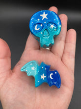Load image into Gallery viewer, Ideal magnet design to adorn your refrigerator, lockers, workstation, toolbox, or dishwasher. This hand-sculpted clay skull and bat statuette boasts stunning ombre coloration, transitioning from dark blue to light blue to recreate the breathtaking look of a starry night sky.