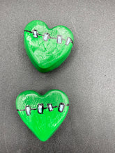 Load image into Gallery viewer, Perfect cute and spooky Halloween item to add to your fridge, locker, cubicle or toolbox. This hand-crafted light and dark green heart-shaped magnet showcases a Frankenstein-inspired design. Measurements: H 1 1/2” x W 1 5/8” x D 1/2”