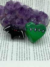 Load image into Gallery viewer, Perfect cute and spooky Halloween item to add to your fridge, locker, cubicle or toolbox. This hand-crafted light and dark green heart-shaped magnet showcases a Frankenstein-inspired design. Cute all black magnet with white highlights and red eyes.