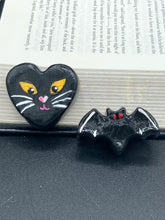 Load image into Gallery viewer, Perfect cute and spooky Halloween magnet art to add to your fridge, locker, cubicle or toolbox. This hand-crafted heart-shaped magnet features a figurine of a black cat with distinctive yellow eyes. Cute all black with white highlights and red eyes magnet.